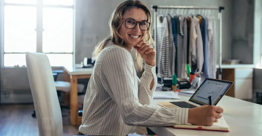 Власник бізнесу працює за ноутбуком в офісі — рішення про перехід з дешевого хостингу